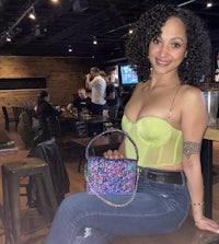 a woman sitting on a bench holding a purse
